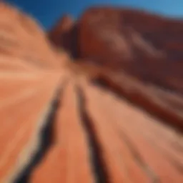 Striking red rock formations with prominent black stripes against a clear blue sky