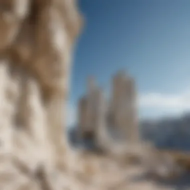 A dramatic landscape featuring white limestone formations against a clear blue sky.